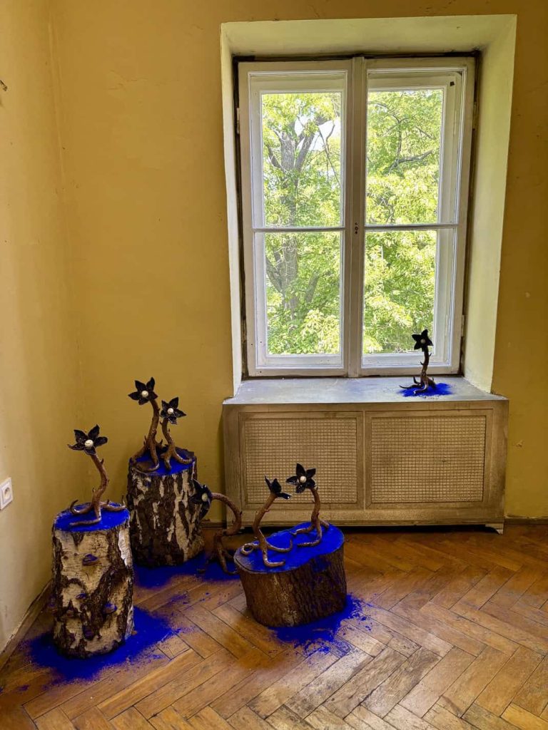 Ceramic sculptures from Magic Plants by Aleksandra Liput displayed on tree trunks Nada Villa Warsaw highlights